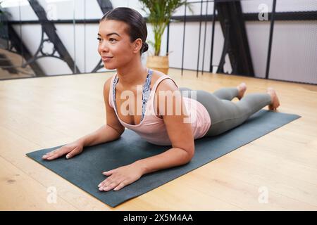 Woman stretching on yoga mat Banque D'Images