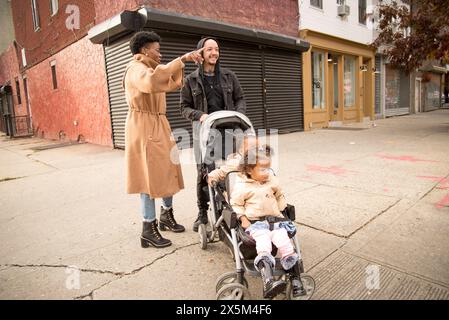 Parents avec des filles en poussette Banque D'Images