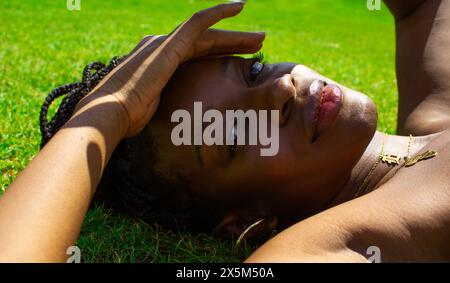 Portrait of young woman lying on grass Banque D'Images