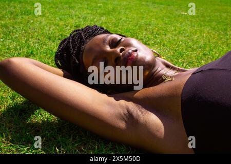 Portrait of young woman lying on grass Banque D'Images