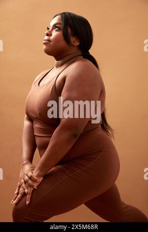 Photo studio d'une femme grande taille qui fait de l'exercice Banque D'Images