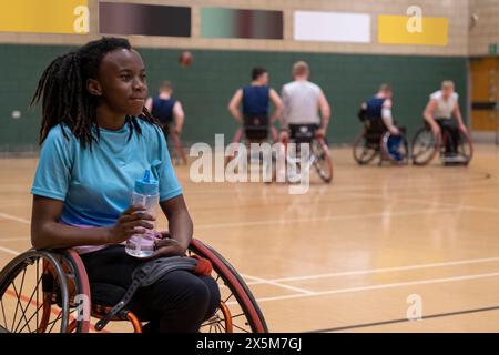 Adolescente en fauteuil roulant ayant une rupture d'eau pendant le match de basket-ball Banque D'Images