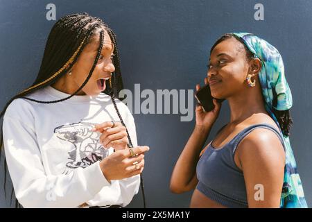 Deux jeunes femmes using smartphone Banque D'Images