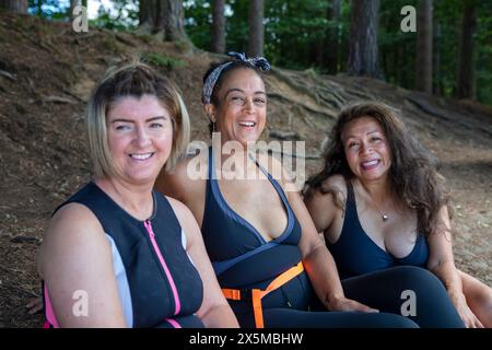 Portrait d'amies féminines souriantes en maillots de bain sur le bord du lac, Yorkshire, Royaume-Uni Banque D'Images