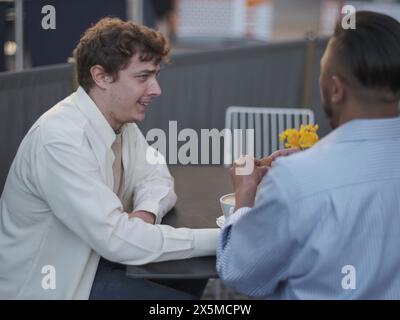 Royaume-Uni, South Yorkshire, couple gay appréciant le café à la table de café Banque D'Images