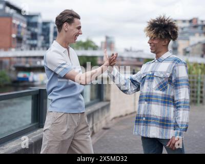 Jeunes hommes faisant la routine de poignée de main Banque D'Images