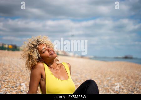 Woman sunbathing on beach Banque D'Images