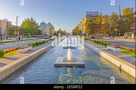 Krusevac, Serbie - 12 octobre 2023 : longue fontaine d'eau avec geysers sur la place de la ville après-midi d'automne. Banque D'Images