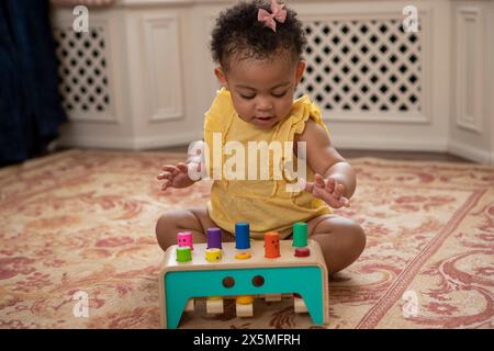 Bébé fille (12-17 mois) jouant à la maison Banque D'Images