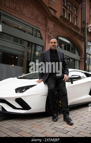 Homme mûr appuyé contre la voiture de luxe Banque D'Images