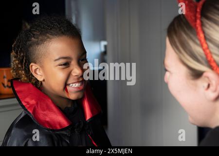 Gros plan d'une femme souriante avec son fils habillé en vampire pour Halloween Banque D'Images