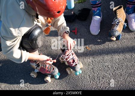 Femme se préparant à faire du patin à roulettes Banque D'Images