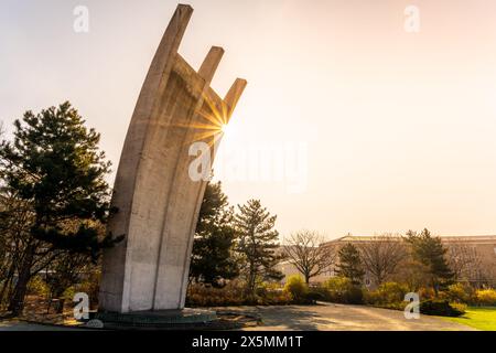 Le Berlin Airlift Memorial baignait dans la lueur chaude d'un lever de soleil, avec le terminal de l'aéroport Tempelhof en arrière-plan. Banque D'Images