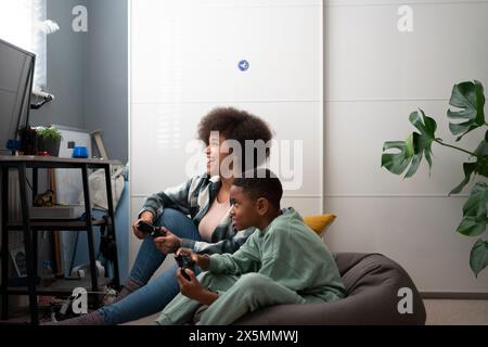 Mère et fils jouant aux jeux vidéo à la maison Banque D'Images