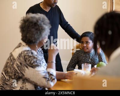 La famille est assise à table et prend le petit déjeuner Banque D'Images