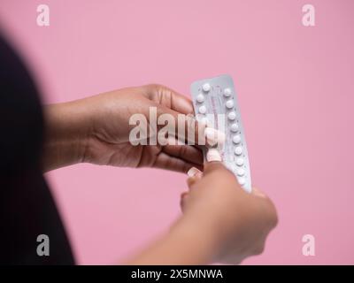 Gros plan de la main de femmes tenant des pilules contraceptives Banque D'Images