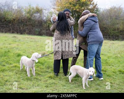 Couple avec des chiens saluant avec des amis seniors dans la nature Banque D'Images