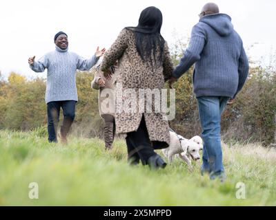 Couple avec des chiens saluant avec des amis seniors dans la nature Banque D'Images