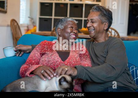 Couple senior avec chat assis sur le canapé Banque D'Images