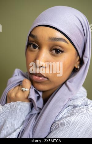 Portrait d'une jeune femme en hijab sur fond vert Banque D'Images