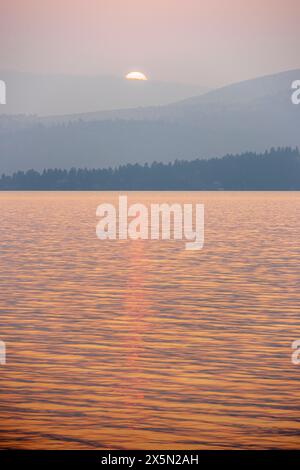 États-Unis, Montana, Flathead Lake. coucher de soleil pendant la fumée de feu de forêt. Banque D'Images