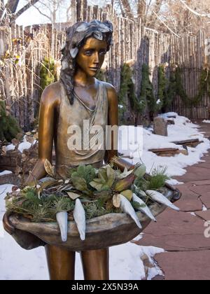 États-Unis, Nouveau-Mexique, Sante Fe. Statue en bronze d'une jeune femme tenant un bain d'oiseaux avec des fleurs et des oiseaux. (Usage éditorial uniquement) Banque D'Images