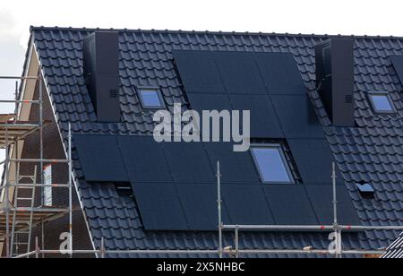 Panneaux solaires sur les toits en tuiles des nouveaux bâtiments. Banque D'Images