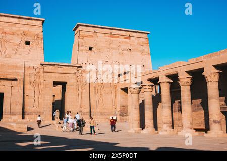 Un groupe de touristes se tient dans la cour du temple d'Isis sur l'île de Philae en Egypte Banque D'Images