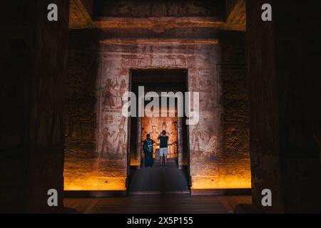 Les touristes examinent la sculpture rocheuse à l'intérieur du Grand Temple d'Abu Simbel dans le sud de l'Egypte Banque D'Images