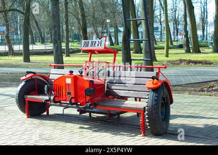 Voiture pour enfants avec sièges en bois et échelle. Utilisé comme zone photo. Jouet géant stationnaire. Activité dans un parc de loisirs de la ville Banque D'Images