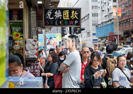 Hong Kong, Chine. 08 mai 2024. Les piétons passent devant un magasin de change de devises avec un panneau offrant : Dollar AMÉRICAIN ($), Yen japonais (¥), Livre sterling (£), Euro (€), Bitcoin (BTC, BCH), Won coréen et Peso philippin à Hong Kong. (Photo de Sebastian Ng/SOPA images/SIPA USA) crédit : SIPA USA/Alamy Live News Banque D'Images