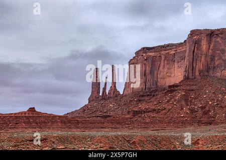 Célèbre trois Sœurs dans Monument Valley est un vestige fortement érodé d'une butte et s'élève à côté d'une longue chaîne de montagnes faite de grès, moenkopi et Banque D'Images