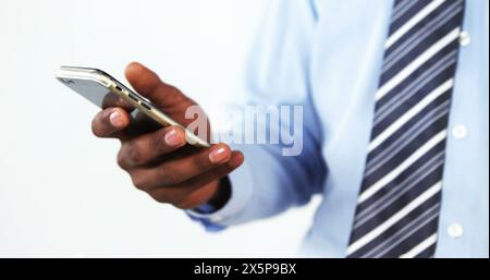 Homme afro-américain tenant smartphone, portant chemise et cravate Banque D'Images