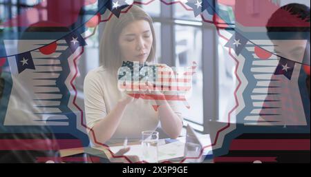 Une jeune femme asiatique tenant le drapeau américain, regardant réfléchie Banque D'Images