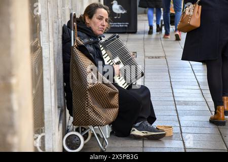 Femme joueur d'accordéon busking dans les rues de Bath, Somerset - Candid Street shot Banque D'Images