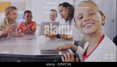 Image du traitement des données boursières sur une fille caucasienne utilisant une tablette numérique à l'école Banque D'Images