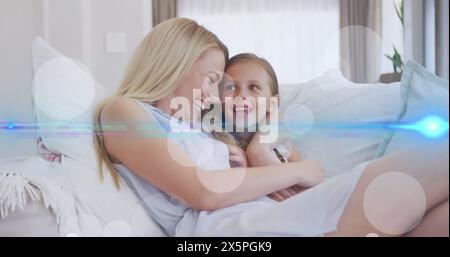 Image de lumière et de points se déplaçant au-dessus de la mère caucasienne heureuse et de la fille parlant sur le canapé Banque D'Images