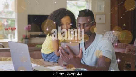 Image de la lumière et des points se déplaçant sur heureux père afro-américain et fille à l'aide de la tablette Banque D'Images