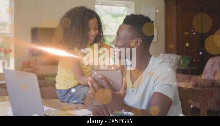 Image de la lumière et des points se déplaçant sur heureux père afro-américain et fille à l'aide de la tablette Banque D'Images