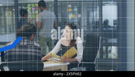 Image de graphiques bleus se déplaçant sur divers collègues masculins et féminins discutant au bureau Banque D'Images