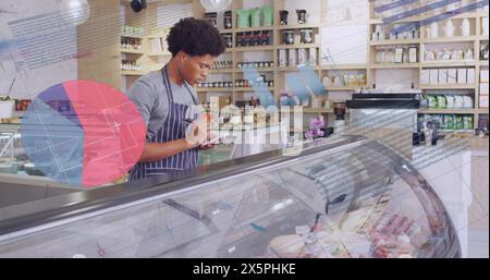Image des nombres et du traitement des données sur l'homme biracial travaillant dans le magasin Banque D'Images