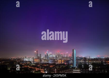 Londres, Royaume-Uni. 11 mai 2024. Météo britannique : les aurores boréales (aurores boréales) sont vues au-dessus des bâtiments du parc d'affaires de Canary Wharf dans l'est de Londres dans un spectacle de lumière rare (une «aurore») également visible à travers le pays. Après une série d’éruptions solaires mercredi, de multiples éruptions de rayonnement solaire se sont maintenant combinées en une seule vague en raison de frapper la Terre ce soir. Crédit : Guy Corbishley / Alamy Live News Banque D'Images