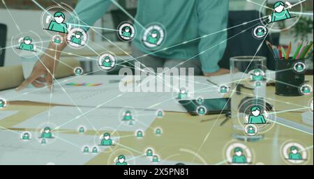 Image d'icônes connectées sur divers collègues discutant des rapports au bureau Banque D'Images