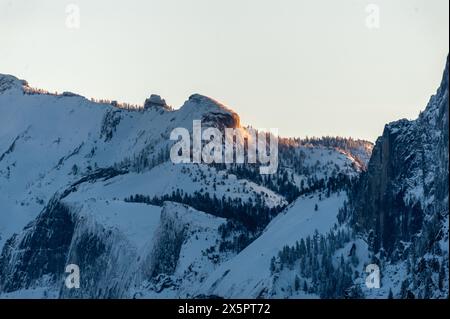 Tôt le soleil attrapant les sommets enneigés de la Sierra Nevadas dans le parc national de Yosemite. Banque D'Images