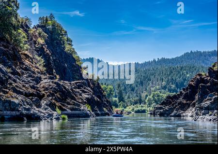 Sauvage et pittoresque rivière Rogue dans le sud de l'Oregon avec un radeau flottant au loin. Banque D'Images