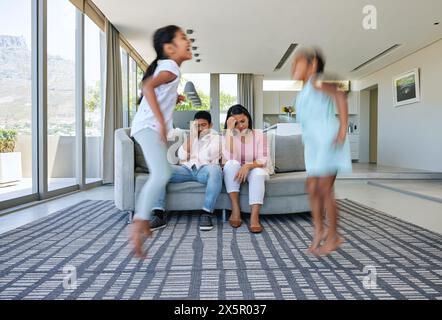 Parents, sauter et stress à la maison, les enfants et fatigués par l'anxiété, l'épuisement professionnel et le bruit dans un salon. Mère, père et enfants énergiques dans un salon Banque D'Images