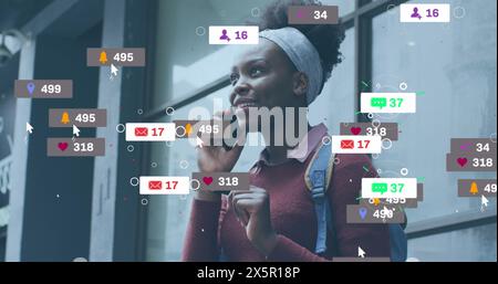 Image d'icônes de médias sociaux avec des chiffres sur la femme afro-américaine parlant sur smartphone Banque D'Images