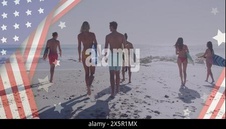 Image du drapeau américain sur un groupe diversifié d'amis marchant avec des planches de surf à la plage Banque D'Images
