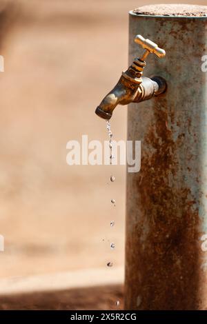 village africain , robinet qui fuit des gouttes d'eau, pénurie d'eau un droit essentiel à l'humanité Banque D'Images