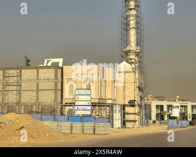 Le Caire, Égypte, mars 27 2024 : chantier de construction d'une nouvelle mosquée avec une structure métallique du dôme et des échafaudages tout le long du minaret du Masjid, Banque D'Images